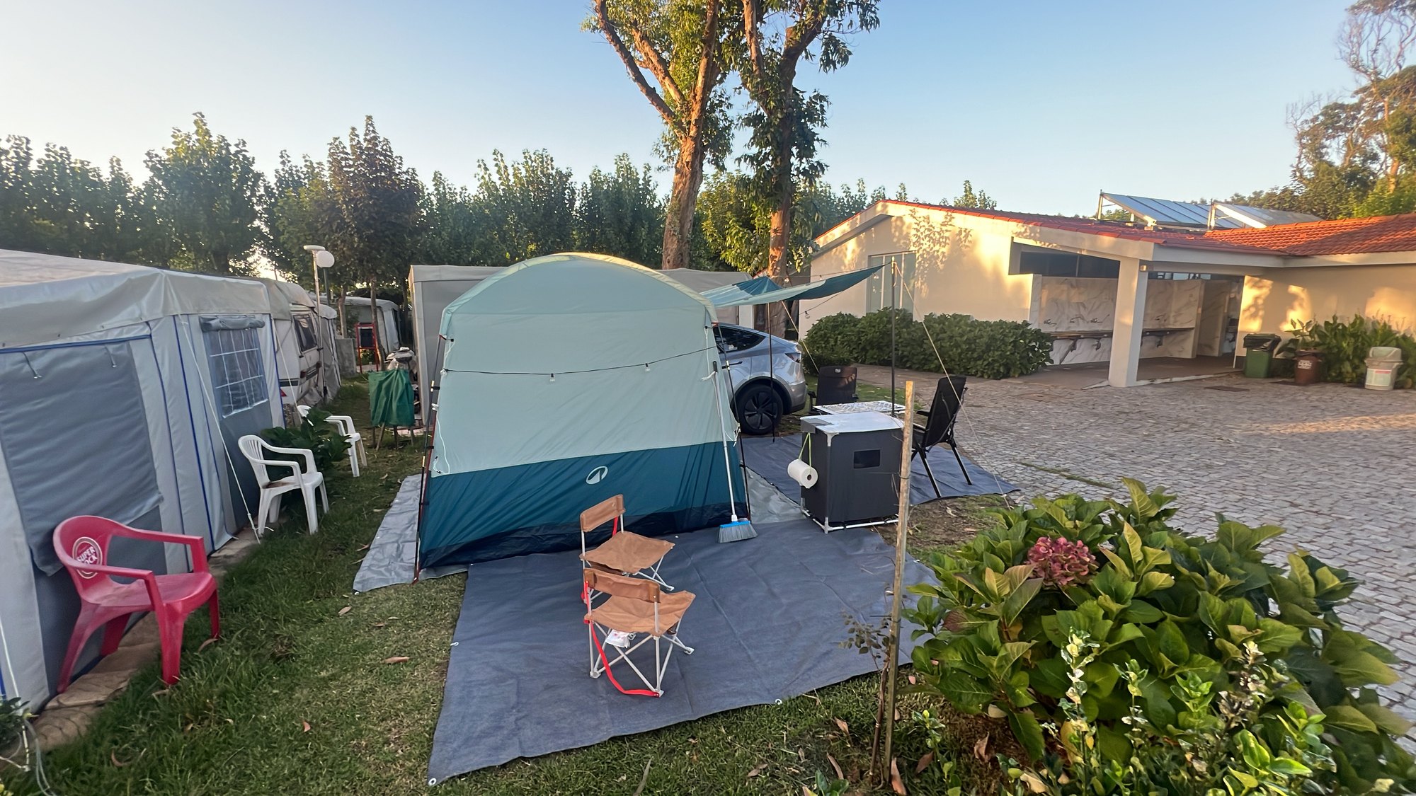 Same pitch, hydrangeas doing Portugal, us halfway packed. Lisbon is tomorrow. About five hours. The tent has been informed.